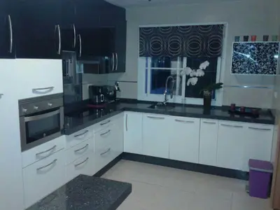 a large kitchen with white cabinets and a window at Casa Paco in Chiclana de la Frontera