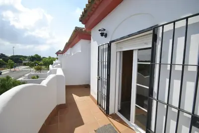 a white building with a sliding glass door at Casa Paco in Chiclana de la Frontera