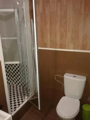 a bathroom with a toilet and a glass shower at Casa Paco in Chiclana de la Frontera