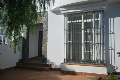 a white building with a gate on the side of it at Casa Paco in Chiclana de la Frontera