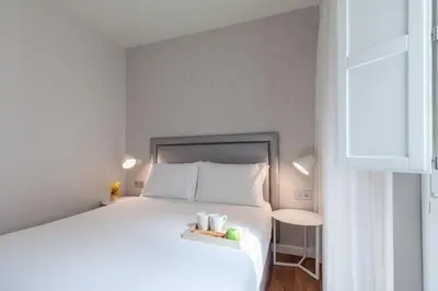 a bedroom with a large white bed and a window at Tandem Ancha 34 in Cádiz