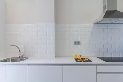 a white kitchen with a sink and a plate of food at Tandem Ancha 34 in Cádiz