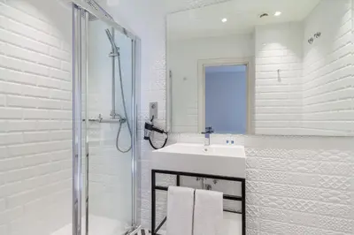 a white bathroom with a sink and a shower at Tandem Ancha 34 in Cádiz