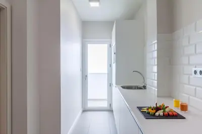 a white kitchen with a plate of fruit on a counter at Tandem Ancha 34 in Cádiz