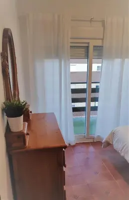 a bedroom with a dresser and a bed and a window at El Mirador de Cadiz in Cádiz