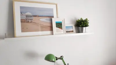 a shelf with two pictures and a lamp on a wall at El Mirador de Cadiz in Cádiz