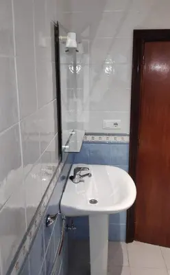 a bathroom with a white sink and a mirror at El Mirador de Cadiz in Cádiz