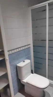 a white toilet in a bathroom with blue tiles at El Mirador de Cadiz in Cádiz