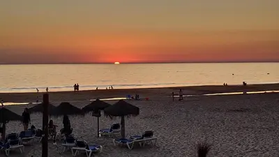 a beach with chairs and umbrellas at sunset at El Mirador de Cadiz in Cádiz