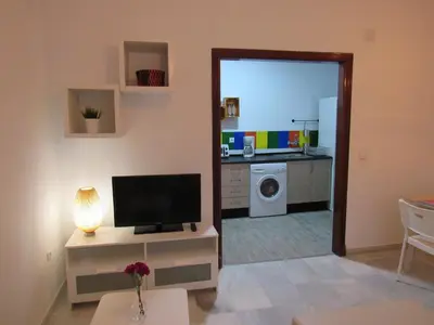 a living room with a television and a kitchen at Apartamento Alameda in Cádiz