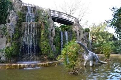 a dinosaur statue in the water next to a waterfall at Apartamento Alameda in Cádiz