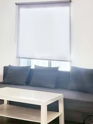 a couch with blue pillows and a white table at Playa de la Caleta, Cadiz in Cádiz
