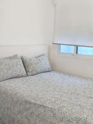 a bedroom with a bed with two pillows and a window at Playa de la Caleta, Cadiz in Cádiz