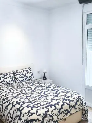 a bedroom with a black and white bed and a window at Playa de la Caleta, Cadiz in Cádiz