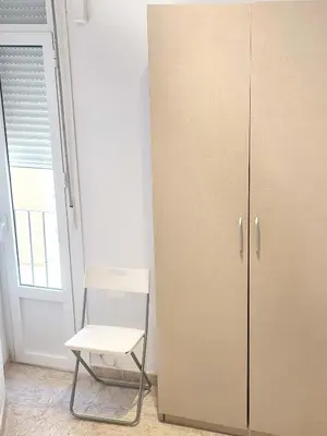 a white cabinet and a chair in a room at Playa de la Caleta, Cadiz in Cádiz