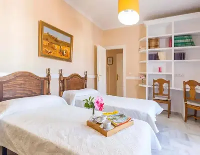 a bedroom with two beds and a table with flowers at Charming house in Arcos with private pool in Arcos de la Frontera