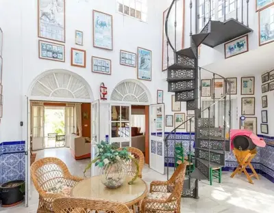 a room with a table and chairs and a wall of pictures at Charming house in Arcos with private pool in Arcos de la Frontera