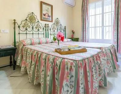a bedroom with a large bed with a floral bedspread at Charming house in Arcos with private pool in Arcos de la Frontera