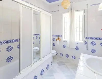 a blue and white bathroom with a toilet and a sink at Charming house in Arcos with private pool in Arcos de la Frontera