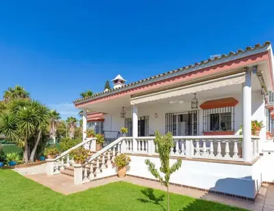 a white house with a porch and a lawn at Charming house in Arcos with private pool in Arcos de la Frontera