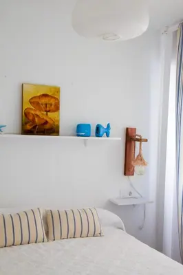 a bedroom with a bed and a shelf on the wall at Vem Al Puerto De Santa Maria in El Puerto de Santa María