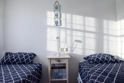 a bedroom with two beds and a table with a lamp at Vem Al Puerto De Santa Maria in El Puerto de Santa María