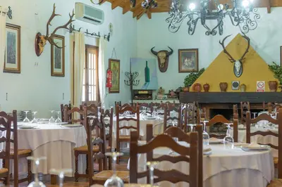 a dining room with tables and chairs and a fireplace at Cortijo Los Monteros in Benalup Casas Viejas