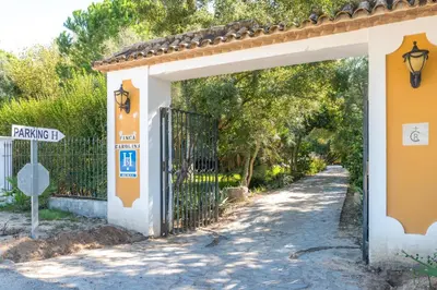 an entrance to a gate to a parking lot at Cortijo Los Monteros in Benalup Casas Viejas