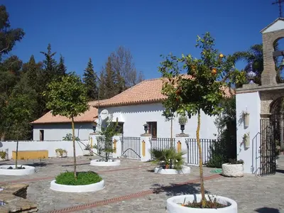 a church with trees in front of a building at Cortijo Los Monteros in Benalup Casas Viejas
