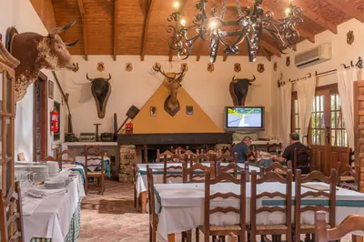 a dining room with tables and antlers on the wall at Cortijo Los Monteros in Benalup Casas Viejas