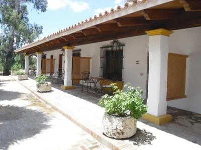 a porch of a white house with potted plants at Cortijo Los Monteros in Benalup Casas Viejas