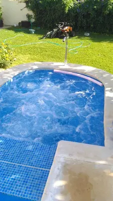 a swimming pool with a fountain in a yard at El chalet del Mar in Chiclana de la Frontera