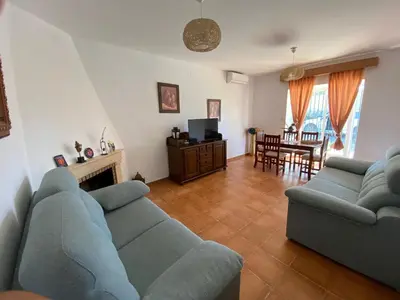 a living room with two blue couches and a table at El chalet del Mar in Chiclana de la Frontera