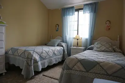 a bedroom with two beds and a window at Villa Valdelagrana fantástica para familias in Cádiz