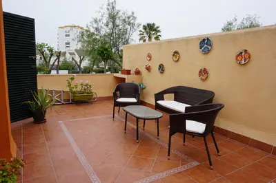 a patio with chairs and plates on a wall at Villa Valdelagrana fantástica para familias in Cádiz