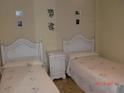 a bedroom with two beds and a night stand at Villa Valdelagrana fantástica para familias in Cádiz