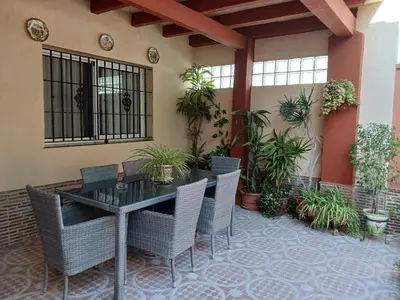 a patio with a table and chairs and plants at Villa Valdelagrana fantástica para familias in Cádiz