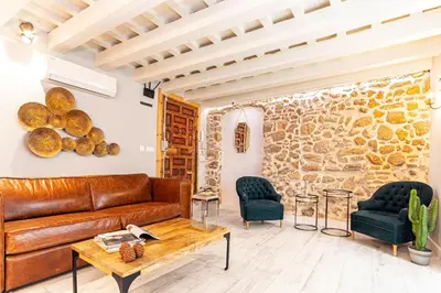 a living room with a leather couch and two chairs at Genteel Home Plaza de España Cádiz in Cádiz