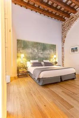 a bedroom with a large bed and a painting on the wall at Genteel Home Plaza de España Cádiz in Cádiz