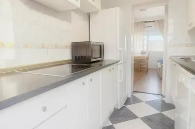 a white kitchen with a microwave on a counter at Apartamento con Vistas al González Byass in Jerez de la Frontera