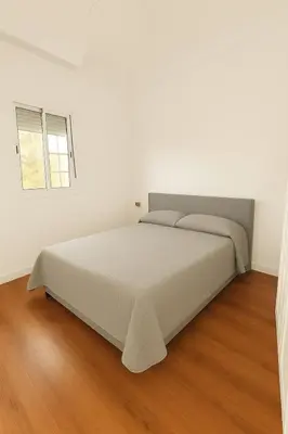 a white bedroom with a large bed in it at Apartamento con Vistas al González Byass in Jerez de la Frontera
