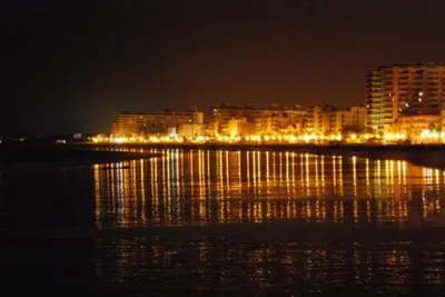 a city at night with lights on the water at Apartment in Rota Cadiz, terrace AC wifi in Rota