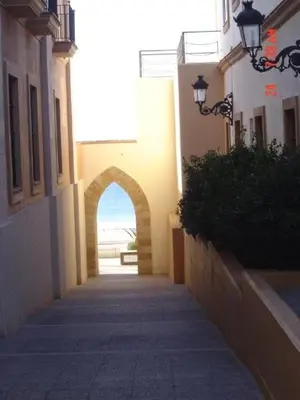 an alley way with an arch in a building at Apartment in Rota Cadiz, terrace AC wifi in Rota