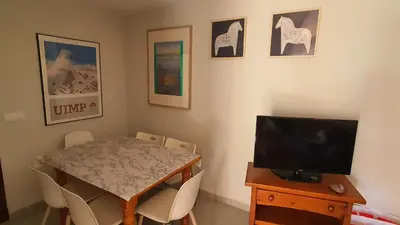 a dining room with a table and a television at Apartment in Rota Cadiz, terrace AC wifi in Rota