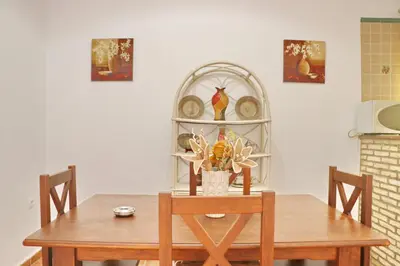 a dining room table with two chairs and a plate shelf at Chalet Chaparrillo Conil in Conil de la Frontera
