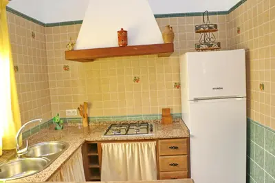 a kitchen with a white refrigerator and a sink at Chalet Chaparrillo Conil in Conil de la Frontera