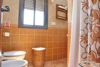 a bathroom with a toilet and a sink and a window at Chalet Chaparrillo Conil in Conil de la Frontera