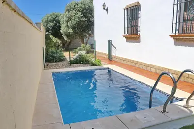 a swimming pool in the backyard of a house at Chalet Chaparrillo Conil in Conil de la Frontera