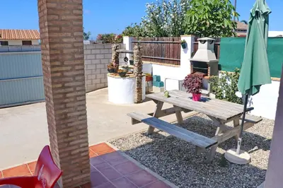 a patio with a picnic table and an umbrella at Chalet Chaparrillo in Conil de la Frontera