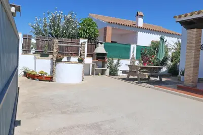 a patio of a house with a bench and a table at Chalet Chaparrillo in Conil de la Frontera